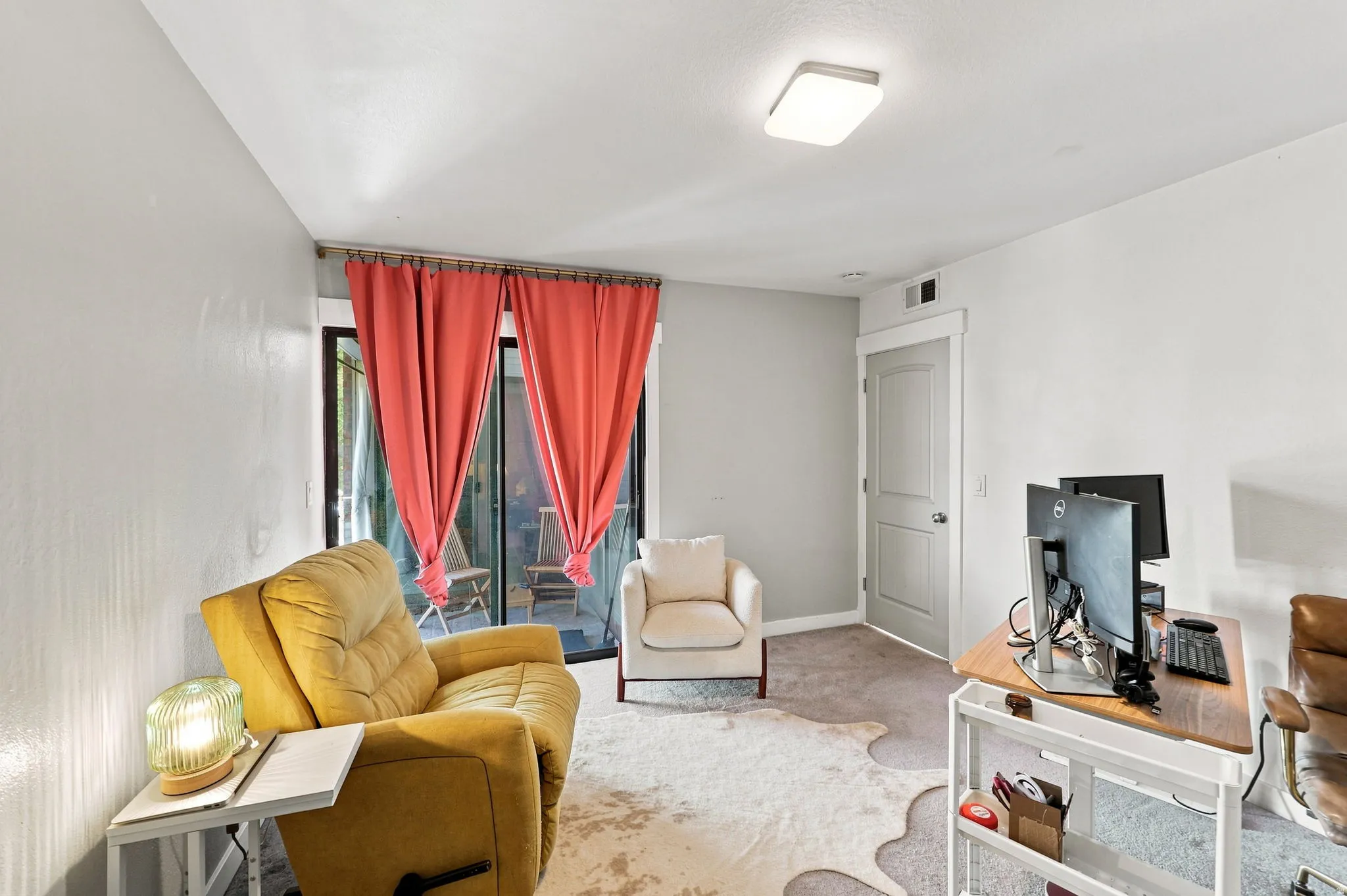Sliding glass door, wall-to-wall carpeting, overhead flush mount lighting, and a paneled interior door