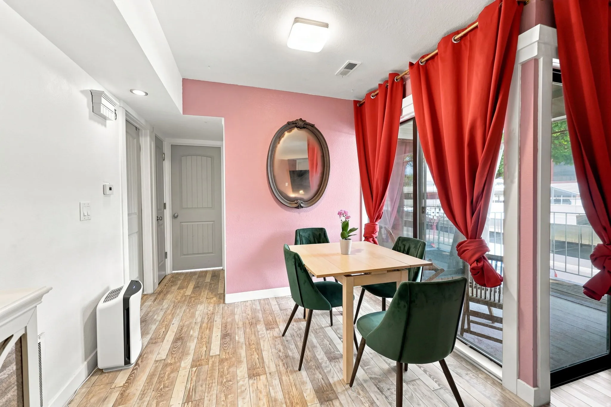 Wood-finish flooring, recessed lighting, and a glass sliding door providing access to an exterior balcony