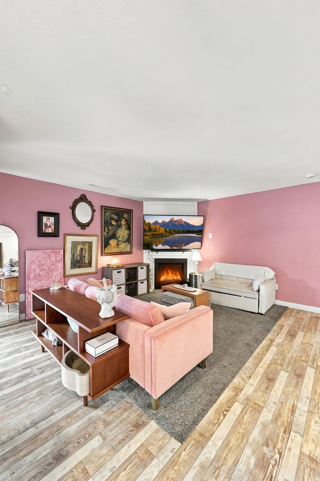 Built-in fireplace with a white mantel, wood-finish flooring, and carpeted area