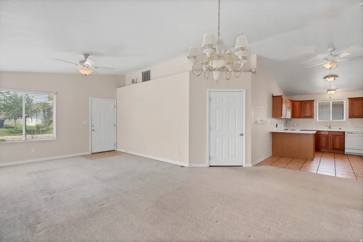 Vaulted ceilings, a kitchen with wood-finish cabinetry, and ceramic tile flooring in the kitchen area