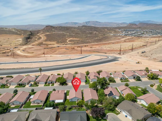 Aerial perspective showcasing established residential area, paved roads, and distant mountainous terrain