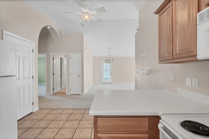 Kitchen with tile flooring and wood-finish cabinetry, featuring a white countertop