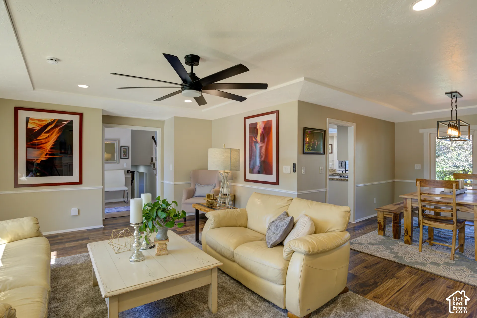 Recessed ceiling lighting, crown molding, a dark wood-finish flooring, a contemporary ceiling fan, and a rustic dining light fixture