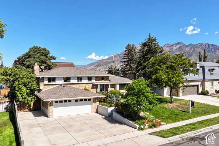 South facing front view of home with a 2 car garage and  rv parking. mountain views from front and back yard.