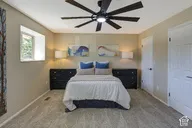 Recessed window, ceiling fan with integrated lighting, two panel doors with black hardware, and light-toned wall paint