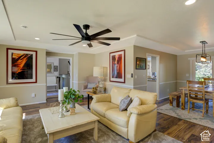 Recessed ceiling lighting, crown molding, a dark wood-finish flooring, a contemporary ceiling fan, and a rustic dining light fixture