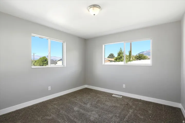 Neutral wall color, wall-to-wall carpeting, white trim, recessed lighting, and multiple windows