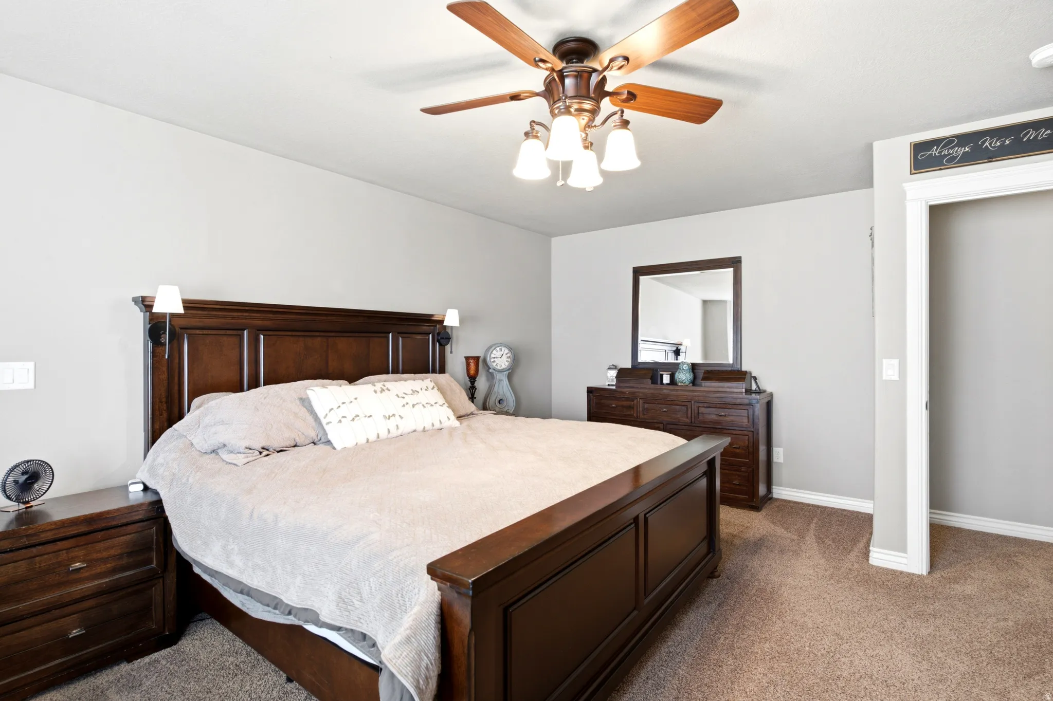 Ceiling fan with integrated lighting, recessed wall sconces, wall-to-wall carpeting, and an open doorway