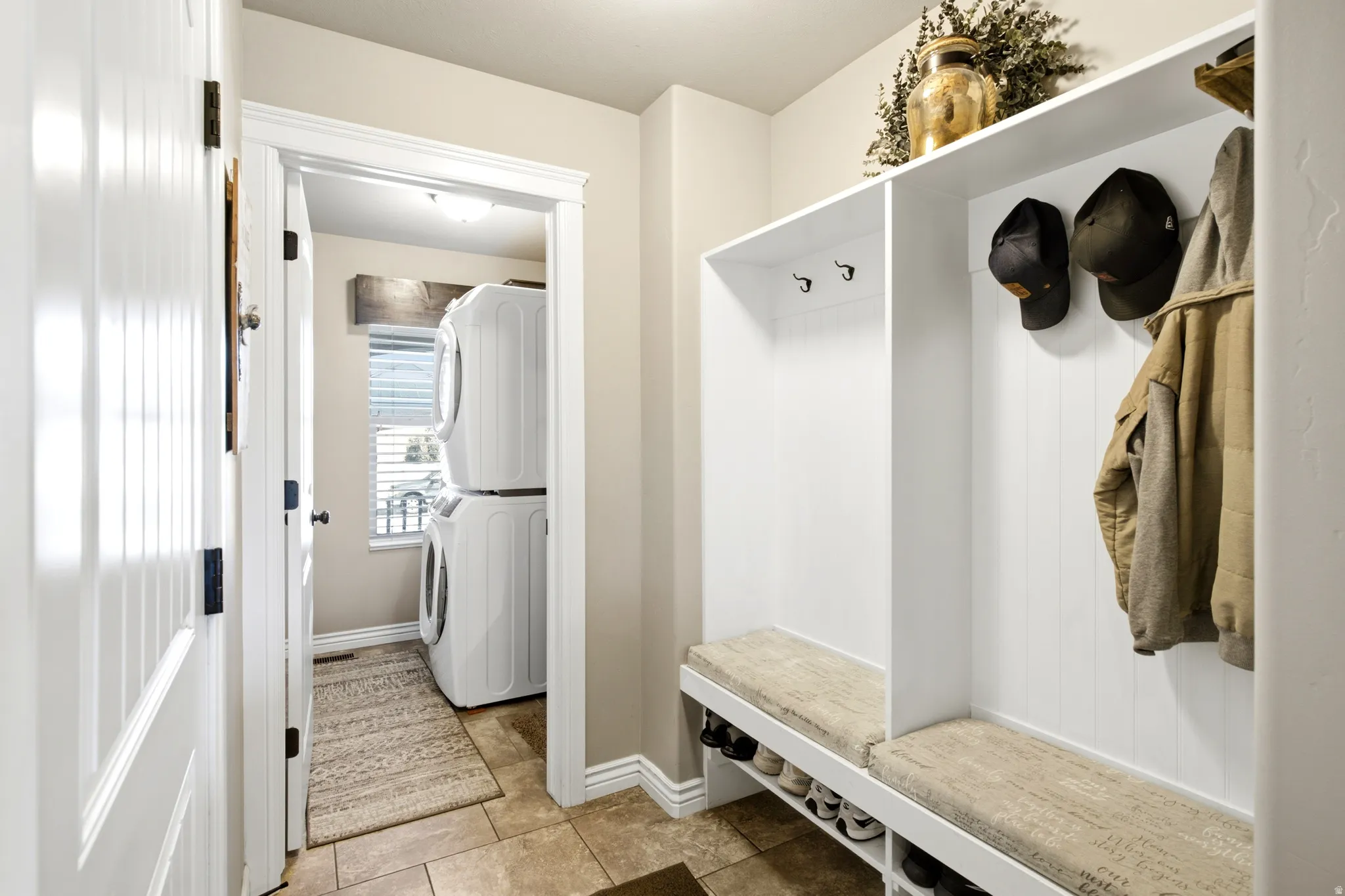 Built-in mudroom seating with storage, white beadboard paneling, and wall-mounted hooks