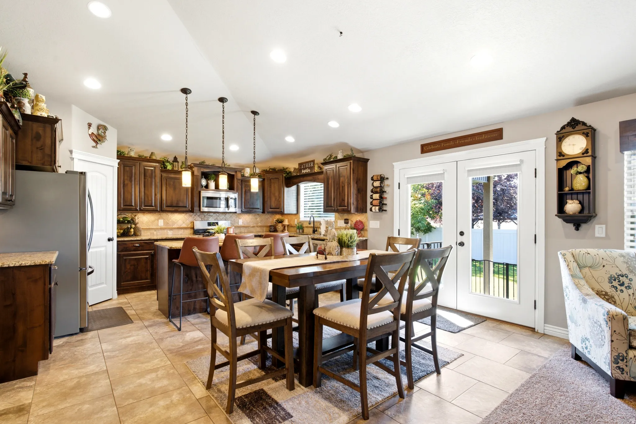 Kitchen featuring recessed lighting, dark wood cabinetry, stainless steel appliances, stone countertops, and a center island with pendant lighting