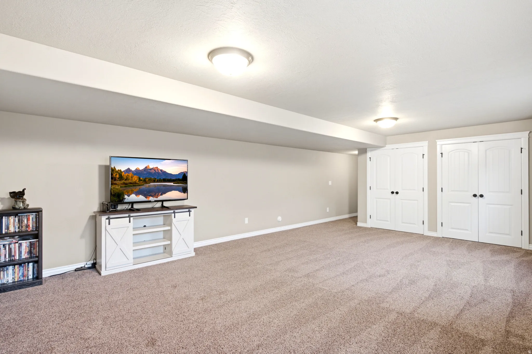 Neutral wall tones, recessed lighting, and carpeted flooring