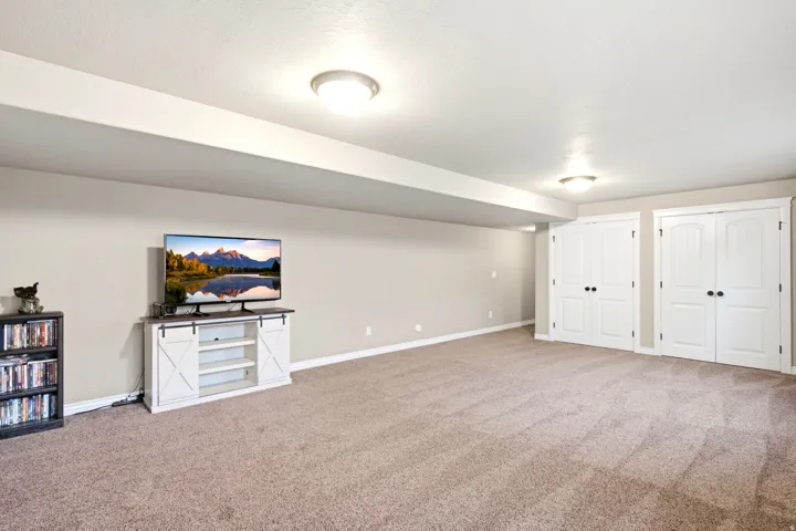 Neutral wall tones, recessed lighting, and carpeted flooring