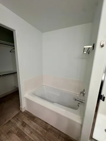 Integrated bathtub with white surround and chrome fixtures