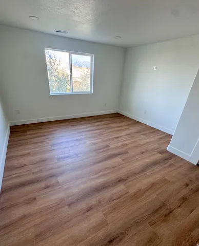 Recessed ceiling lighting, wood-finish flooring, and a large window