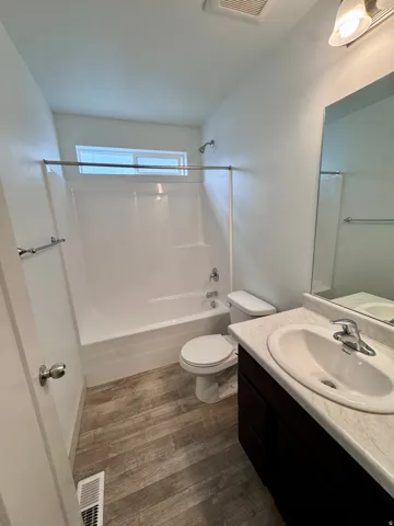 Full vanity with integrated sink, dark wood-finish cabinetry, and a large wall-mounted mirror