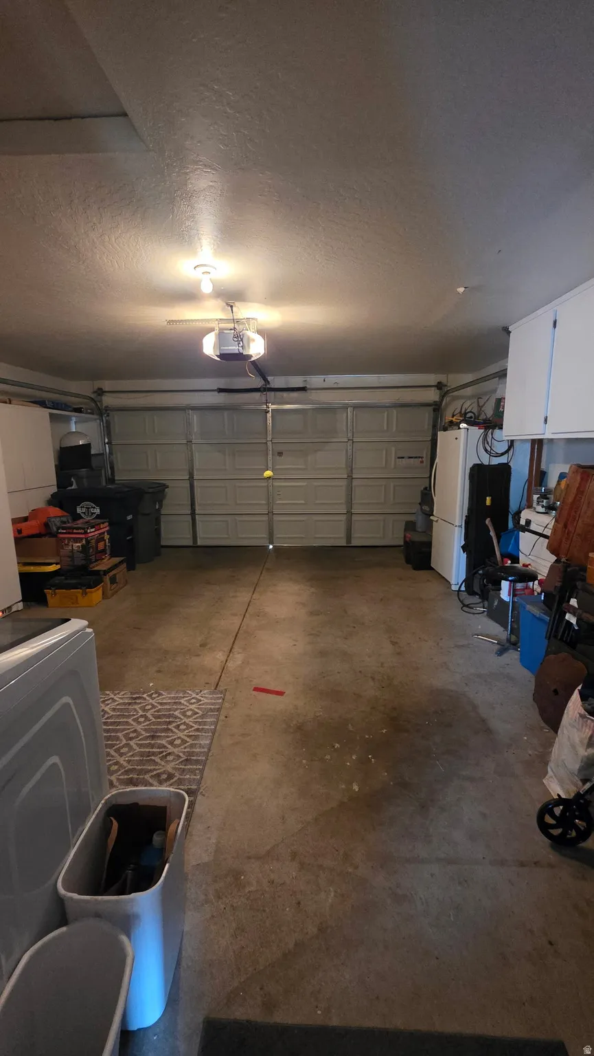 Attached garage featuring a concrete floor and overhead garage door