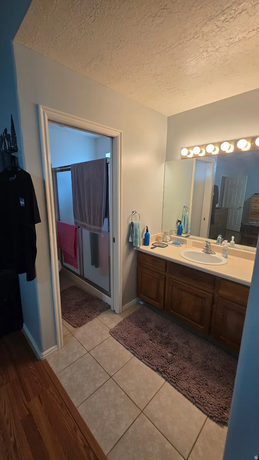 Full vanity with an integrated sink, broad wall mirror, and overhead strip lighting