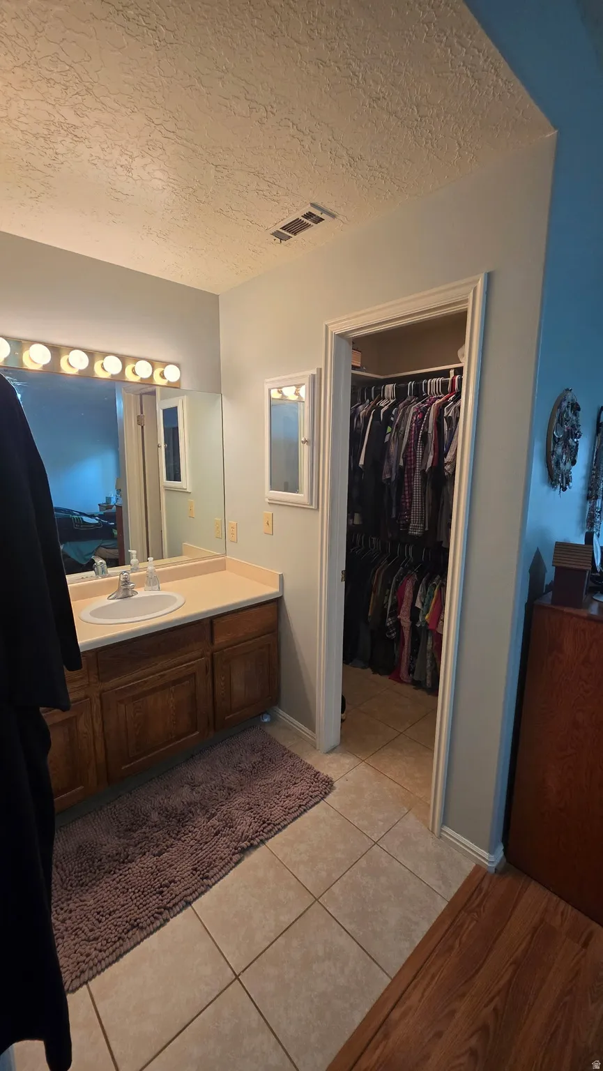 Vanity with a single basin, wood-finish cabinetry, and a countertop