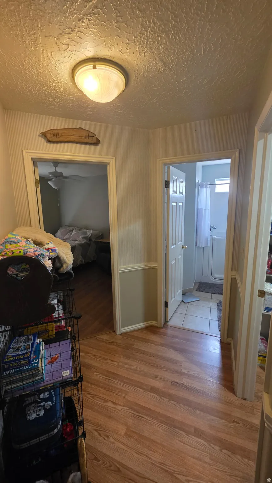 Wood-finish flooring throughout, with a flush-mount ceiling light fixture, and interior doors with panel detailing