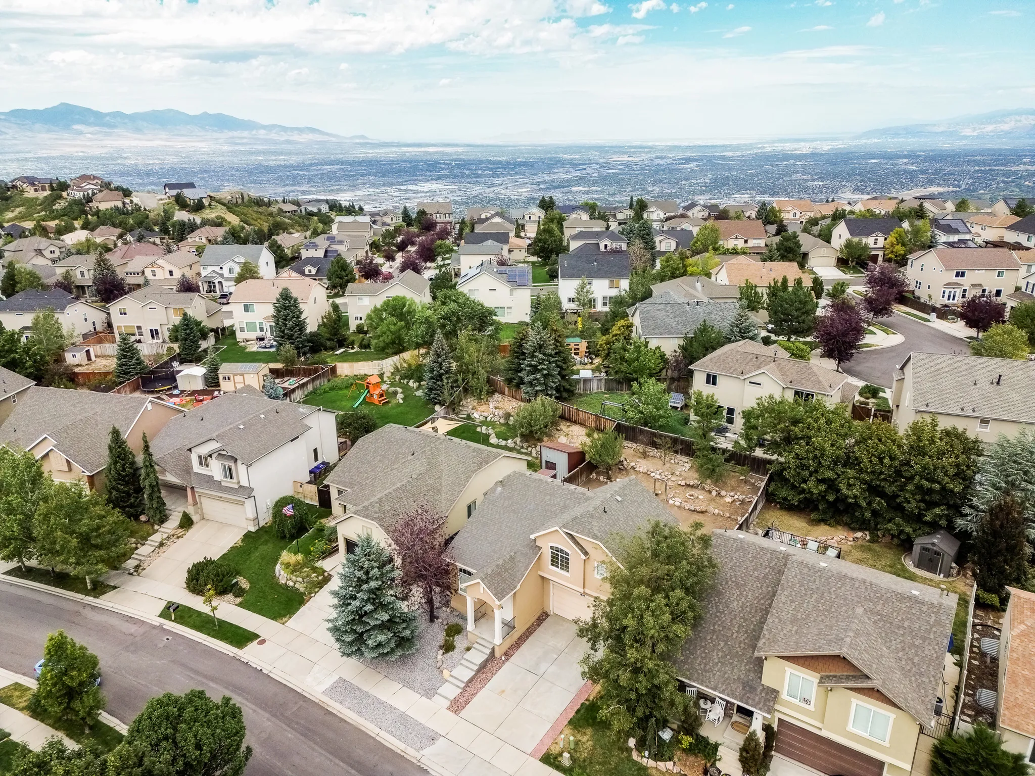 Expansive neighborhood setting with a distant city backdrop and mountain scenery