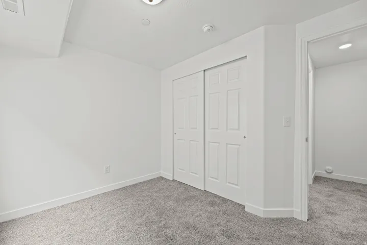 Neutral paint palette with wall-to-wall carpeting and a ceiling-mounted light fixture
