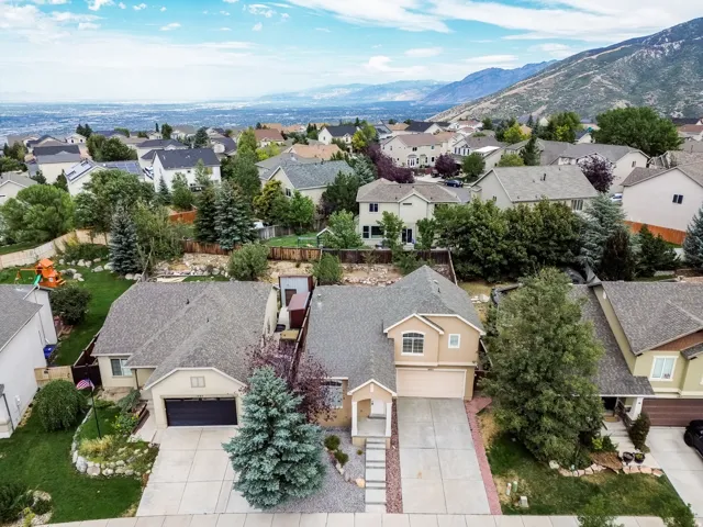 Single-family dwelling with an attached garage, paved driveway, and mature landscaping