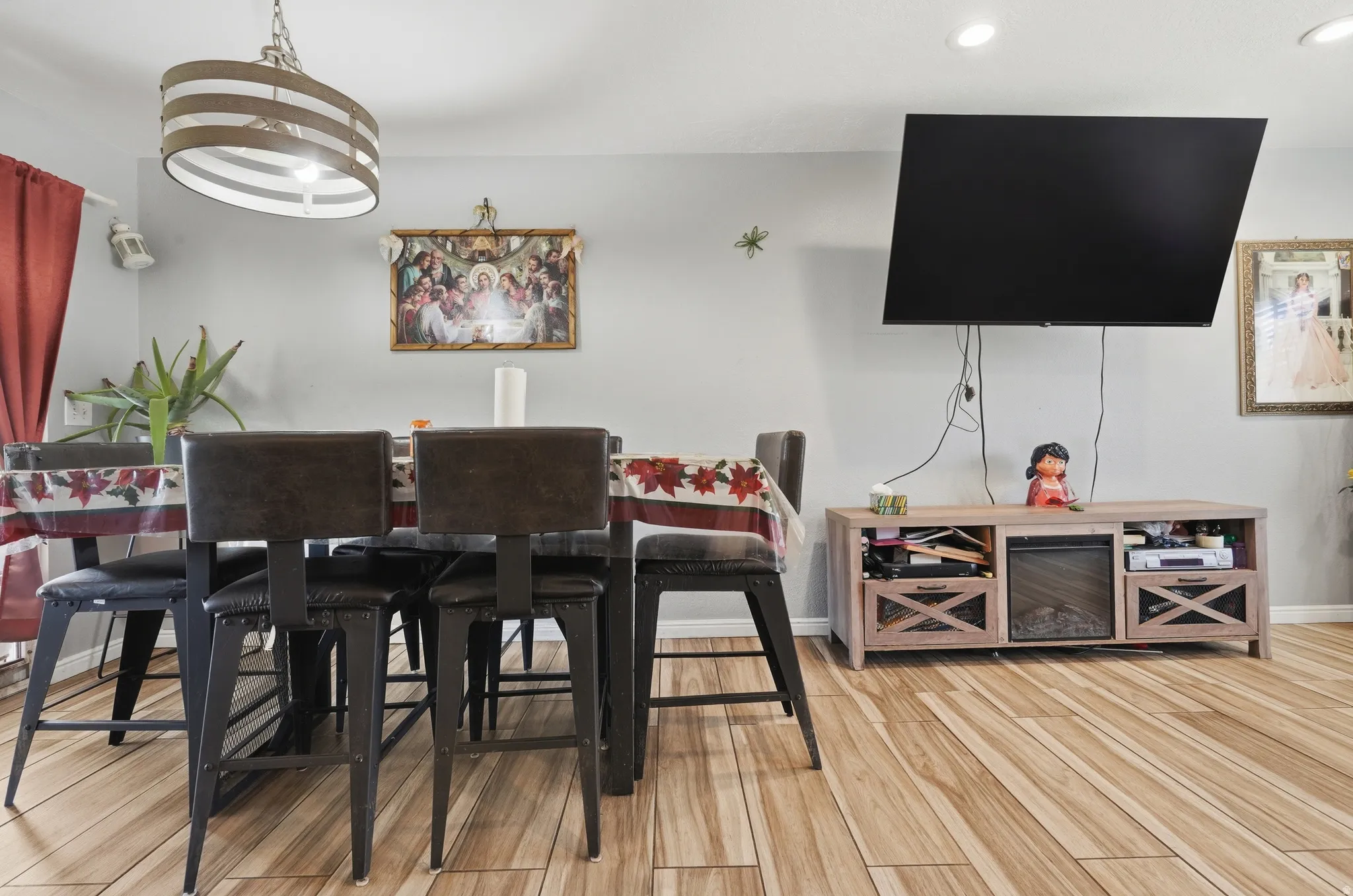 Recessed ceiling lighting, wood-finish flooring, and a dining area with an overhead fixture