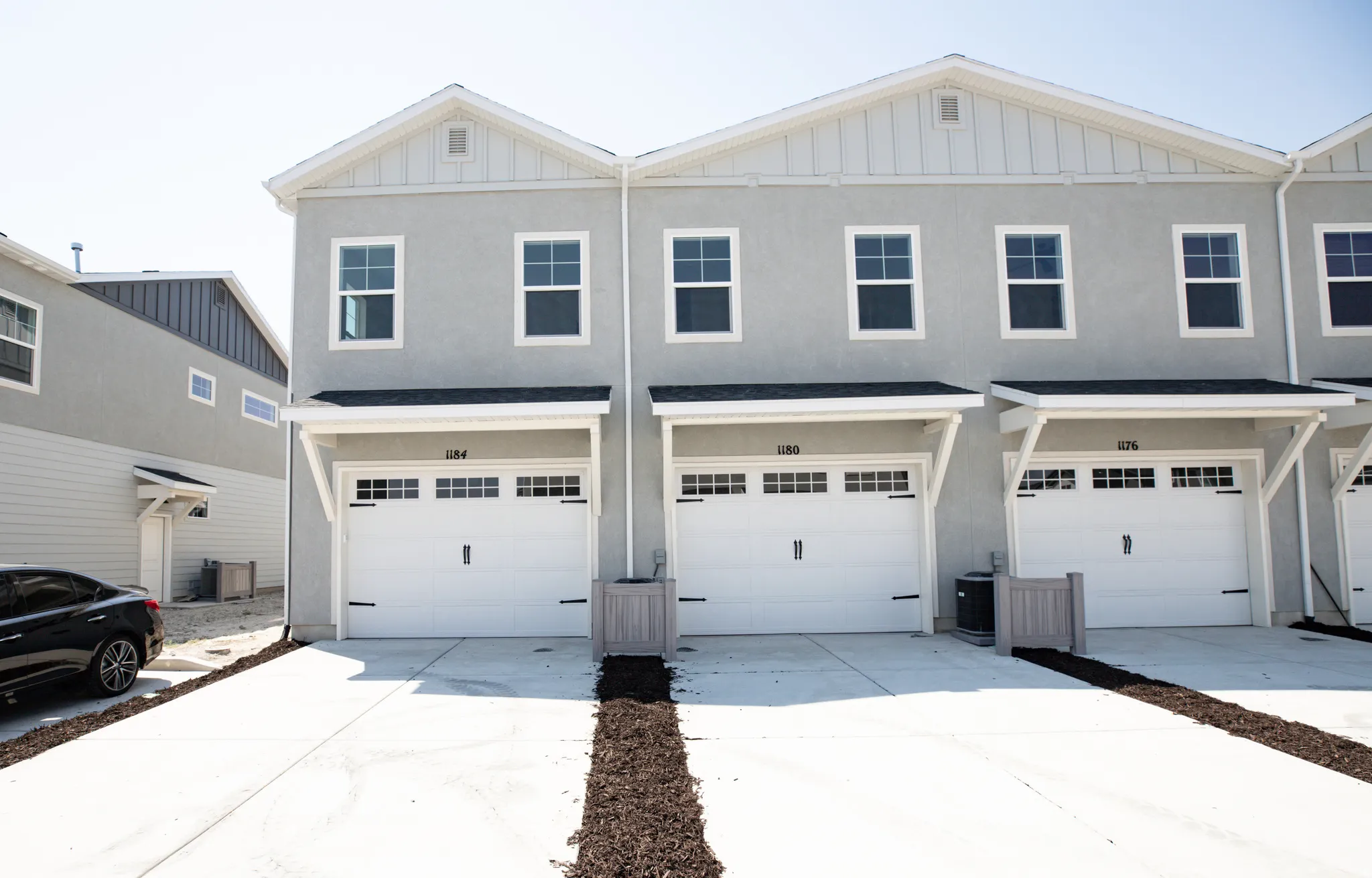 Rear view of end unit townhouse with garage and extended driveway.