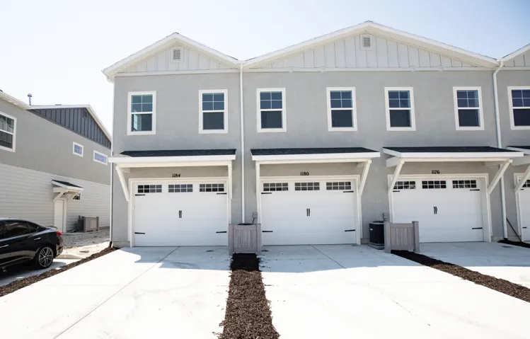 Rear view of end unit townhouse with garage and extended driveway.