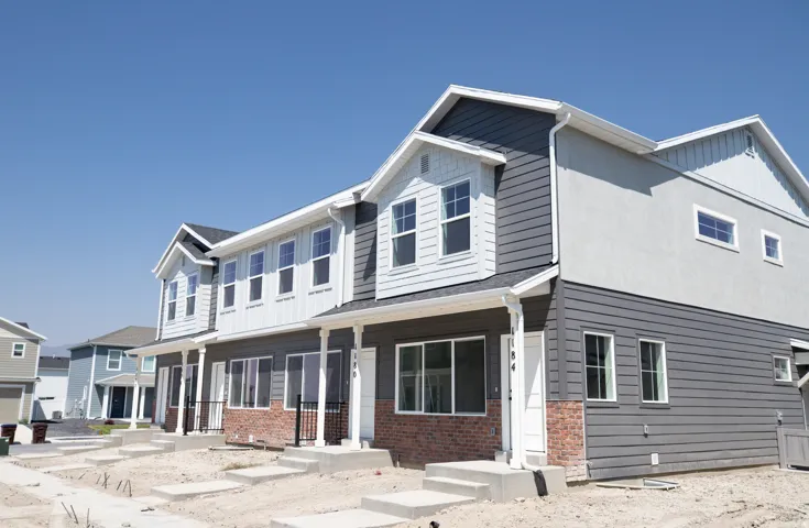 Exterior view of front of end unit townhouse with front yard landscaping to be installed.