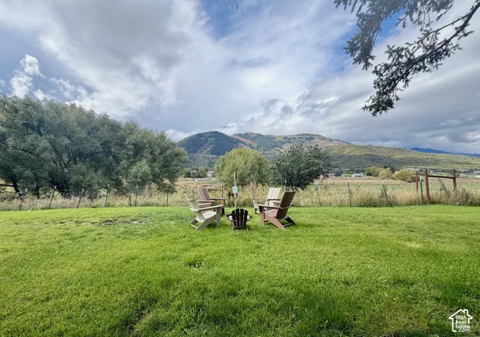 Expansive green lawn with mountain backdrop and mature trees