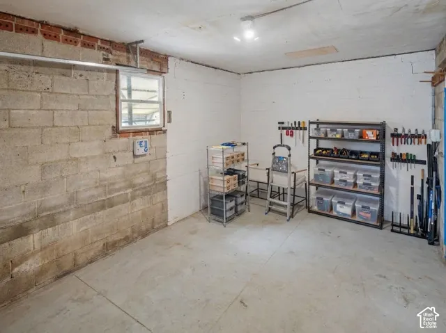 Concrete block walls with a single-pane window, exposed brick detailing, and a concrete floor