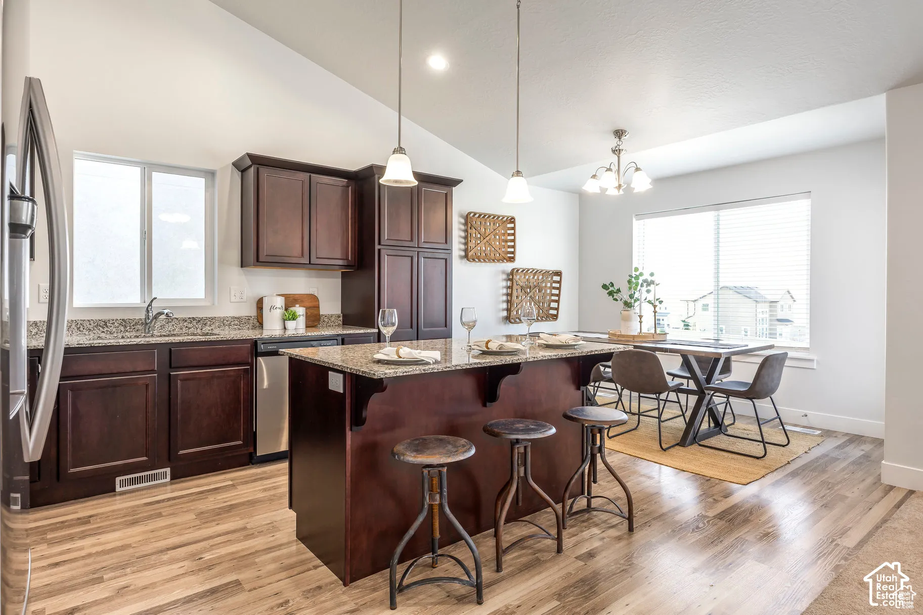 Kitchen featuring wood-finish flooring, dark wood cabinetry, and speckled countertops