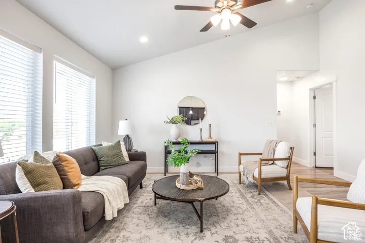Vaulted ceiling, ceiling fan, recessed lighting, wood-finish flooring, and multiple large windows