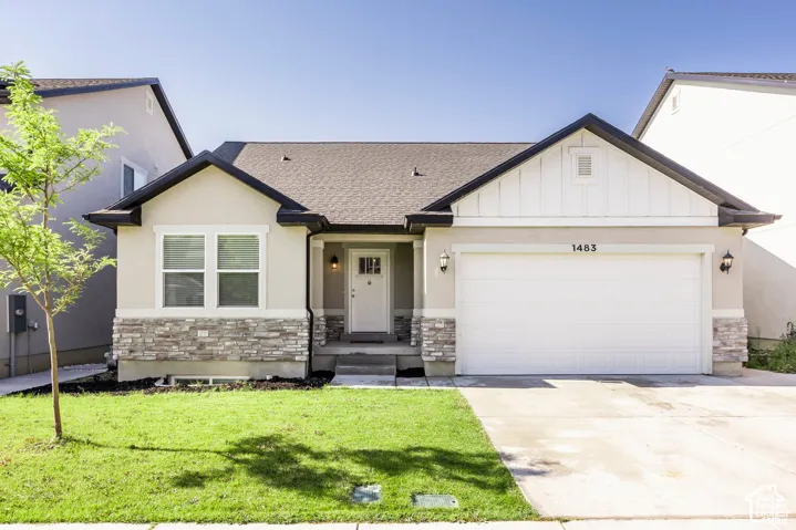 Exterior featuring a two-car garage, stone and stucco facade, dark shingle roof, white trim accents, and a concrete driveway