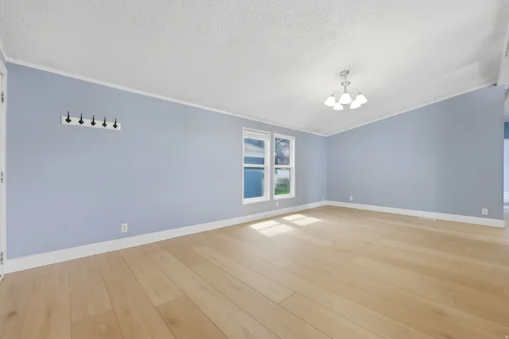 Wood-finish flooring with light-toned walls, white trim, and a ceiling-mounted light fixture