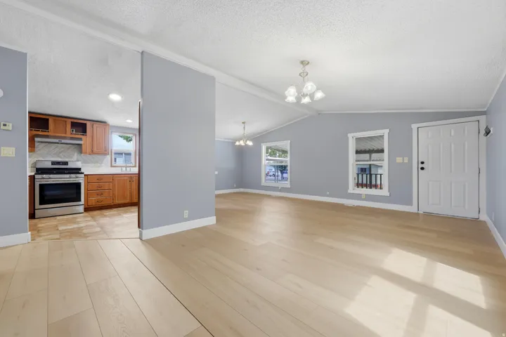 Light wood-finish flooring throughout, vaulted ceiling, and recessed lighting