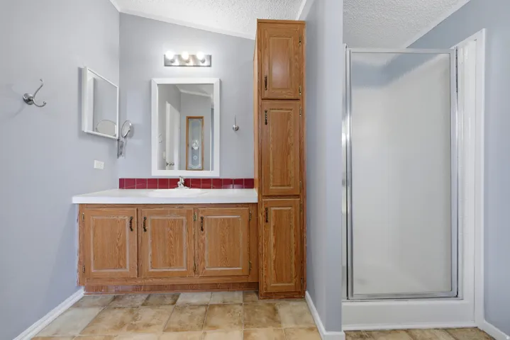 Wood-finish cabinetry with white countertop and integrated sink