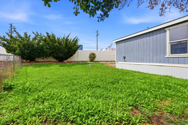 Expansive green yard with perimeter fencing and established shrubbery