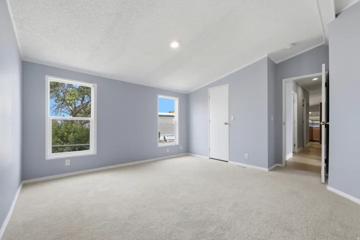 Carpeted room with light-toned walls, white trim, recessed lighting, and dual windows
