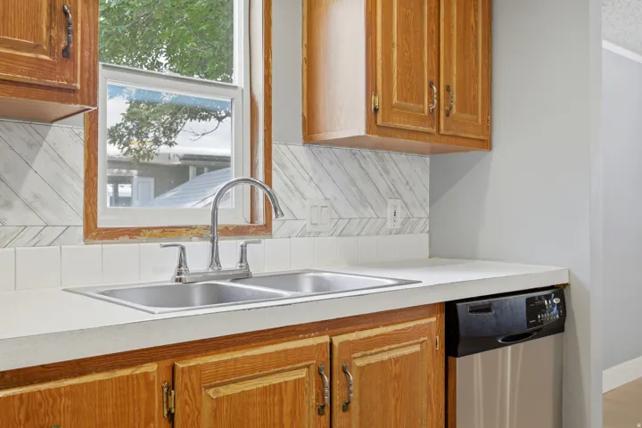 Dual basin stainless steel sink with a high-arc faucet, complemented by a white countertop