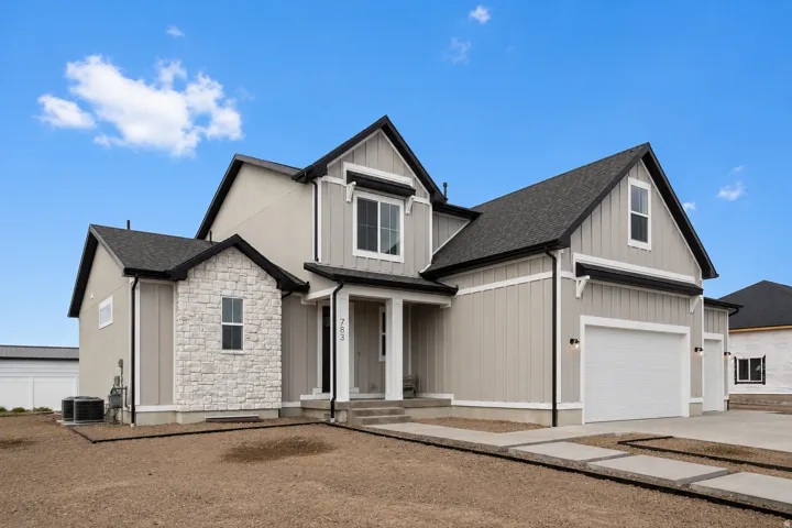 Modern construction featuring a prominent stone facade accent and board and batten siding