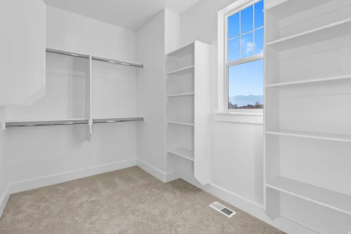 Built-in shelving, hanging rods, and a window with natural light