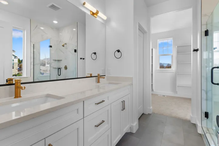 Dual vanity with gold-finish fixtures and stone-finish countertops