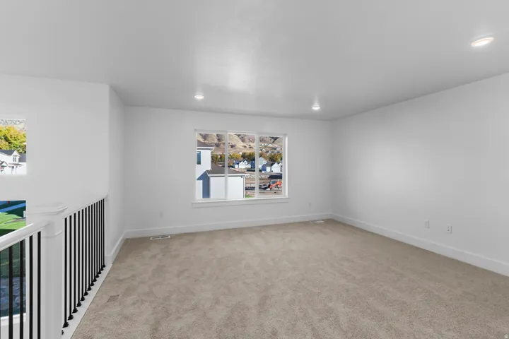 Expansive room with neutral carpeting, recessed lighting, and large windows