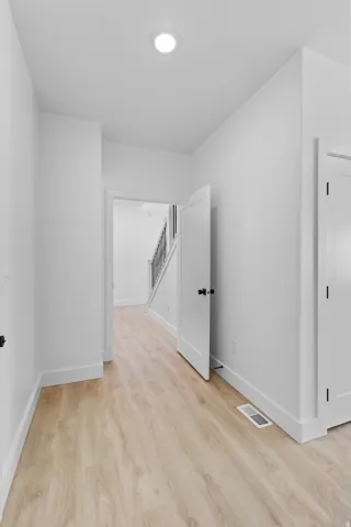Light wood-finish flooring with white baseboards throughout