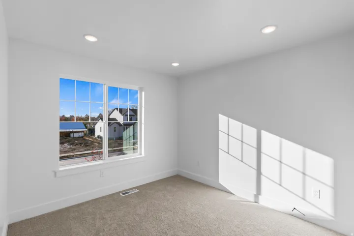 Recessed ceiling lighting, white interior walls, window with grid panes, wall-to-wall carpeting, and white trim