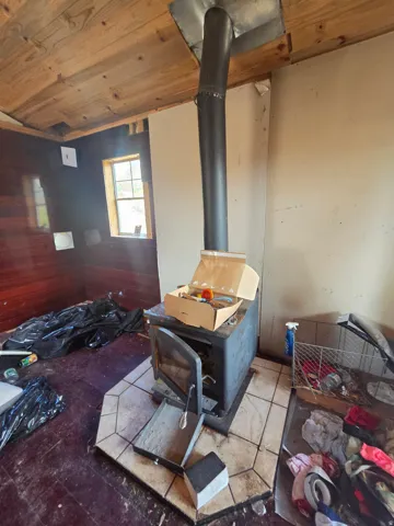 Small off grid cabin/shed with wood burning stove- owners cleaning it up!
