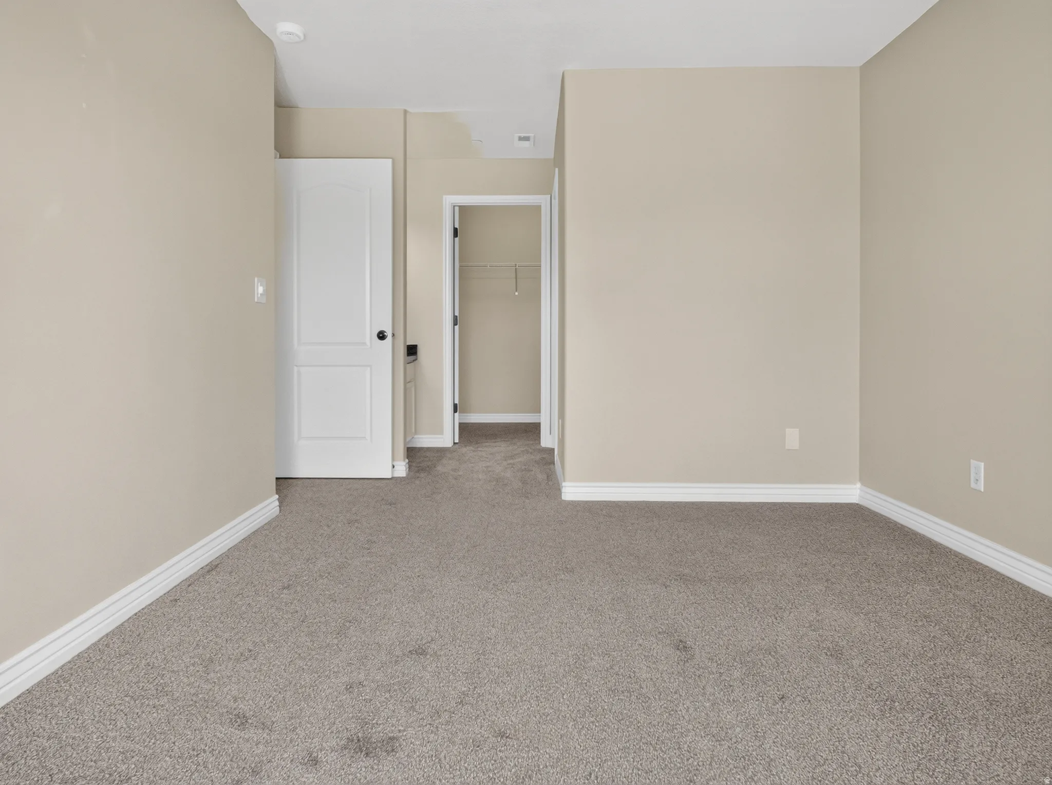 Neutral-toned walls, gray carpet flooring, white trim, and white two-panel doors