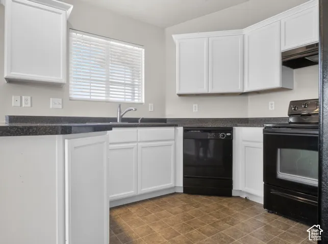 White cabinetry, dark stone-finish countertops, stainless steel sink with a gooseneck faucet, black appliances, and tiled flooring